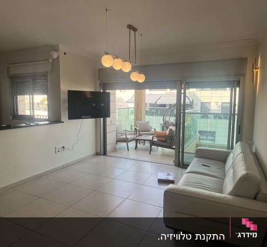 סלון עם ספה, טלוויזיה ותאורה תלויה